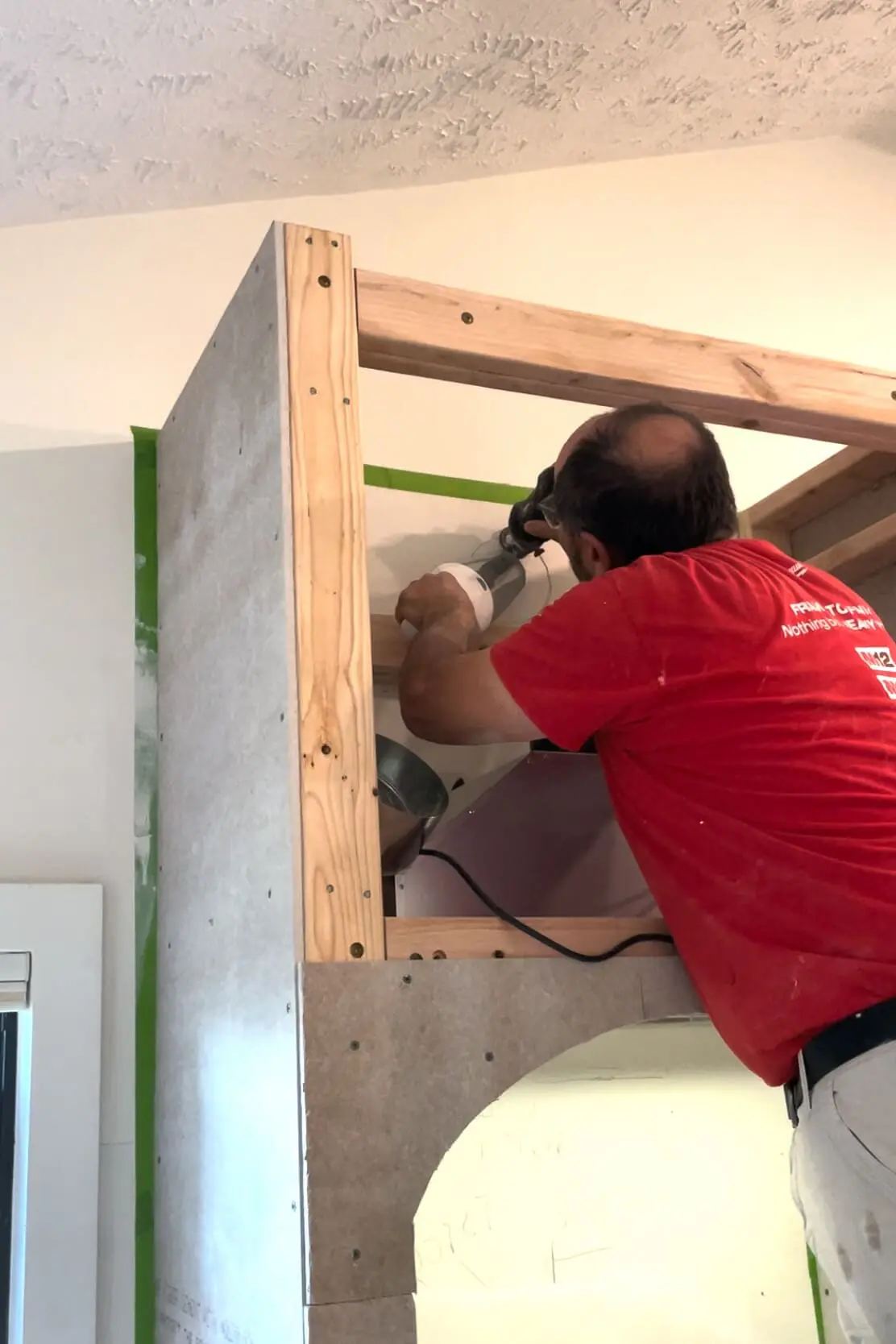 Cutting hole for vent on range hood.